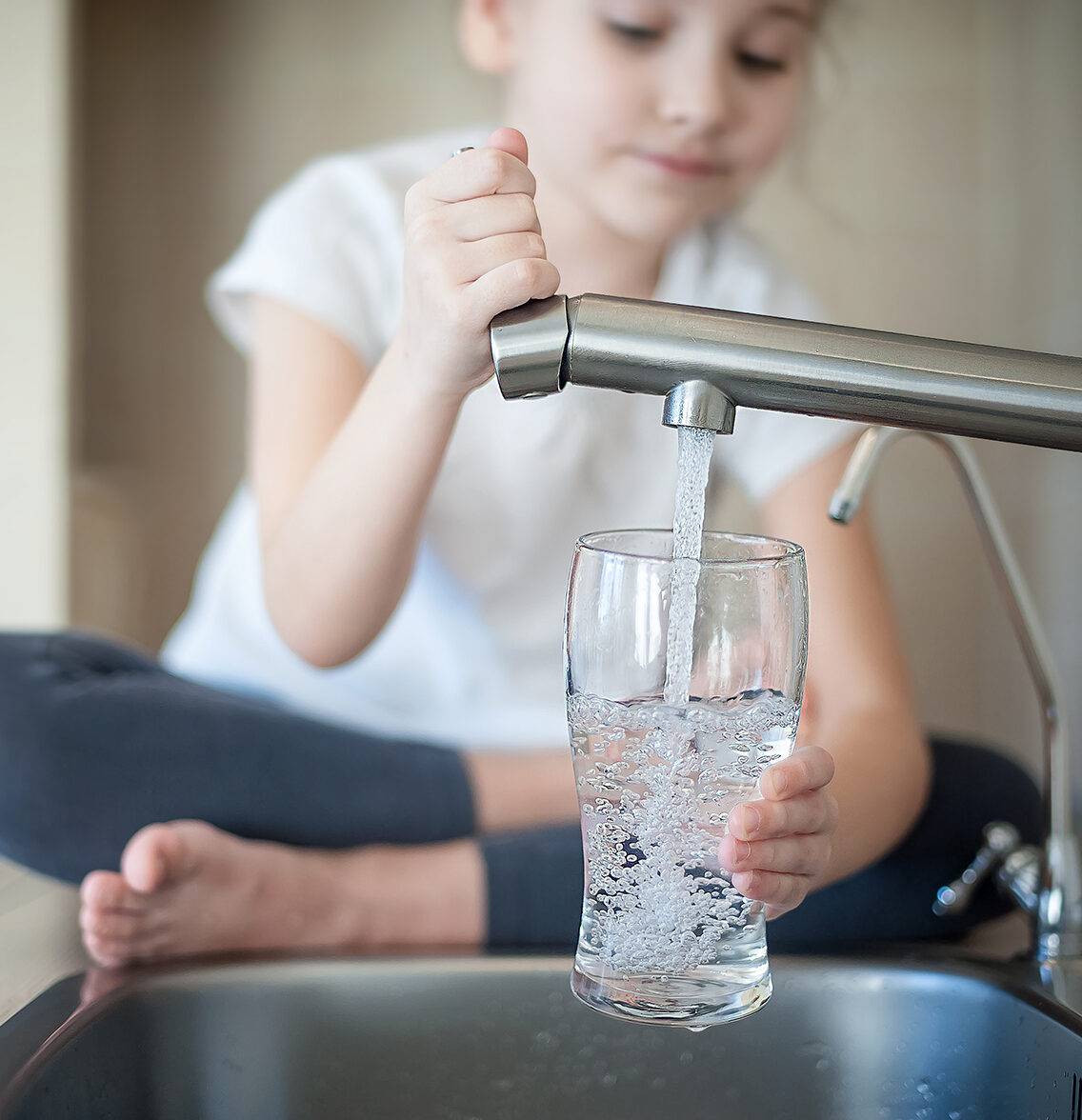 Girl filling cup with filtered tap water